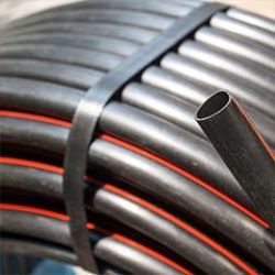 A roll of Irrigation piping with a red line along the side