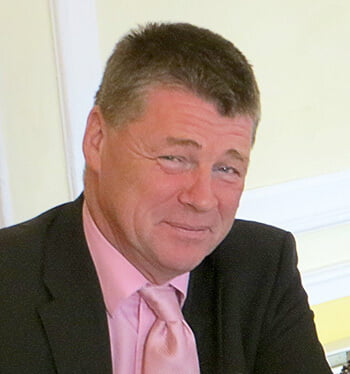 Image of Robert Moore in a suit and pink tie