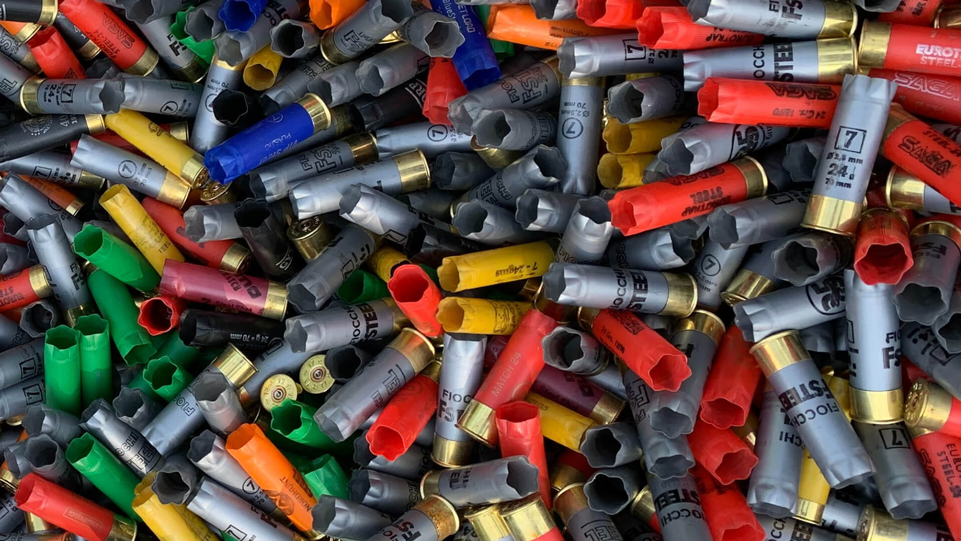 Image of spent shotgun shells with varying colours in a pile
